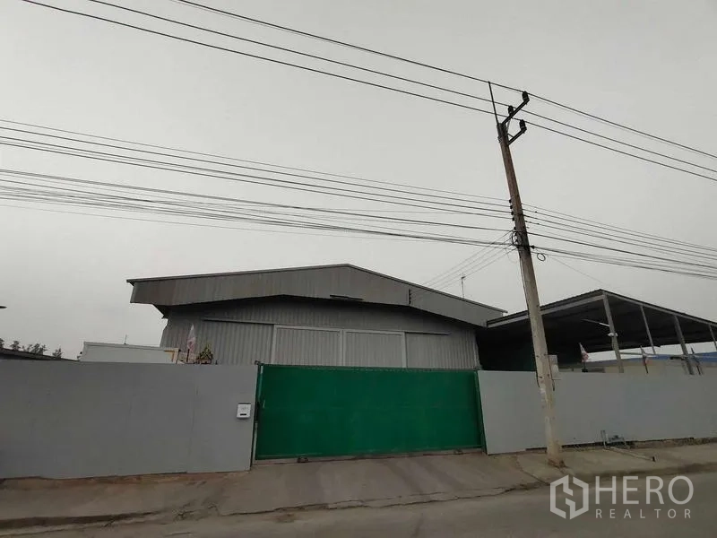 货栈 出售在Lam Luk Ka, Pathum Thani - 金属外墙仓库外观，绿色滑动大门，街边电线杆
