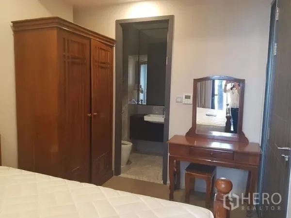 คอนโด ให้เช่าในWatthana, Bangkok - มุมห้องนอนพร้อมตู้เสื้อไม้ โต๊ะเครื่องแป้ง และประตูสู่ห้องน้ำปูกระเบื้อง