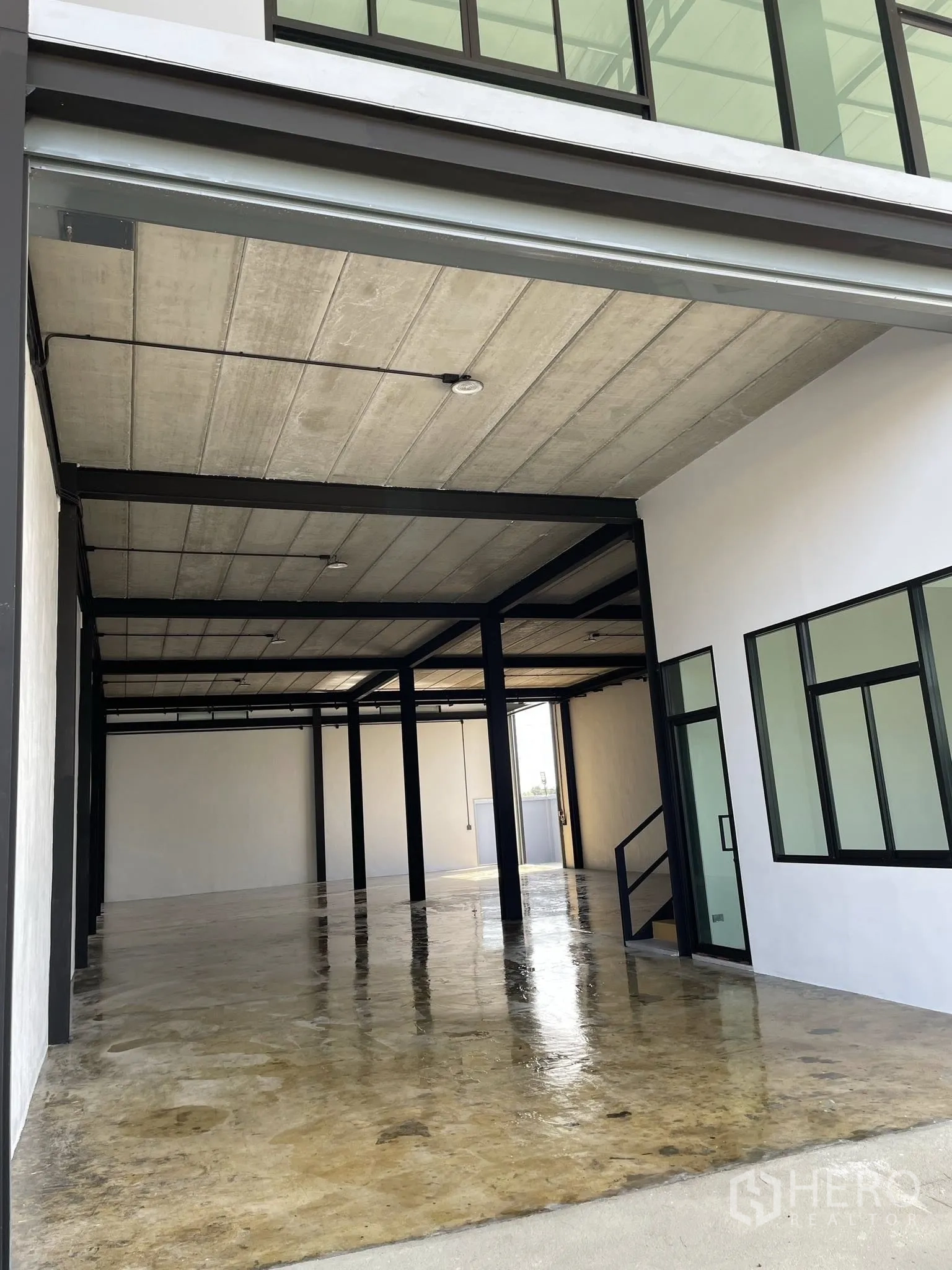 Warehouse for rent in Phra Samut Chedi, Samut Prakan - Ground-floor warehouse space with polished concrete slab and glass entry door.