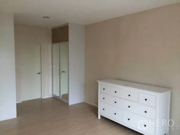 ทาวน์เฮาส์ ขายในSuan Luang, Bangkok - ห้องนอนกว้างพร้อมตู้ลิ้นชักสีขาวและตู้เสื้อผ้าบิลท์อินกระจก