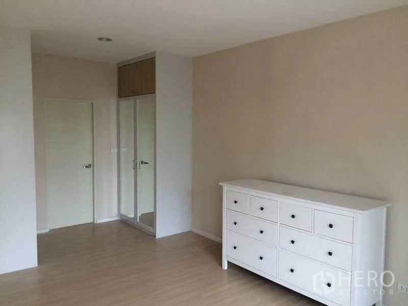 ทาวน์เฮาส์ ขายในSuan Luang, Bangkok - ห้องนอนกว้างพร้อมตู้ลิ้นชักสีขาวและตู้เสื้อผ้าบิลท์อินกระจก