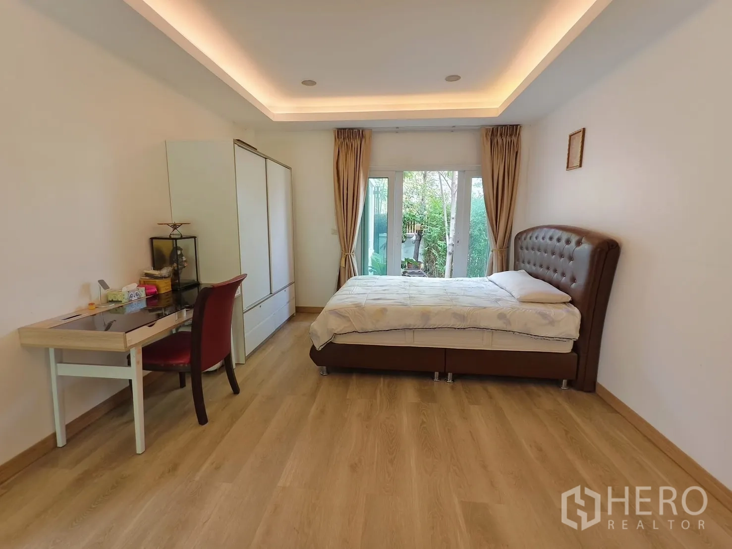 Detached House for rent in Bang Kapi, Bangkok - Ground-floor bedroom with garden access, desk and wardrobe.
