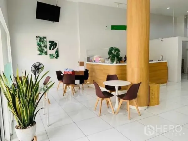 อาคารพาณิชย์ ให้เช่าหรือขายในKhlong Toei, Bangkok - โถงชั้นล่างสว่างพร้อมเคาน์เตอร์ต้อนรับ โต๊ะกลม เสากลม ไม้ประดับ และพื้นกระเบื้องสีขาวมัน