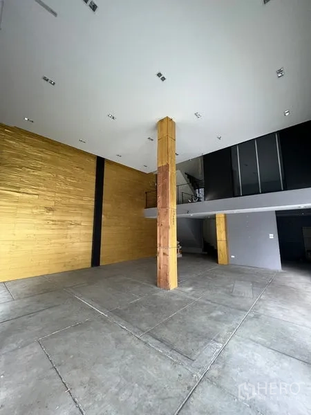 店屋 出租在Watthana, Bangkok - 宽敞挑高大厅，金色装饰墙与中心立柱。