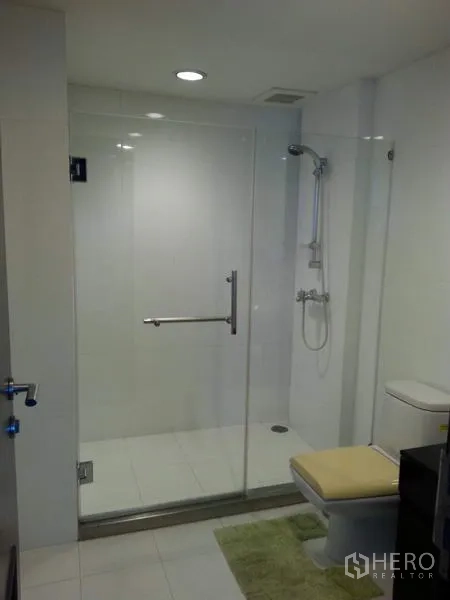 公寓 出租或出售在Pathum Wan, Bangkok - 现代卫浴配玻璃淋浴间、座厕与白色瓷砖。