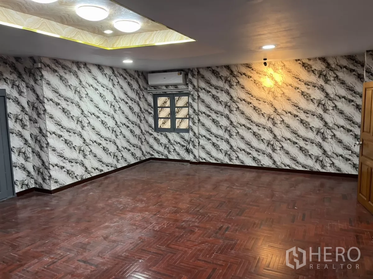 บ้าน ให้เช่าในWatthana, Bangkok - พื้นที่นั่งเล่นขนาดใหญ่ พื้นปาร์เกต์ วอลเปเปอร์ลายหินอ่อน และไฟดาวน์ไลท์.