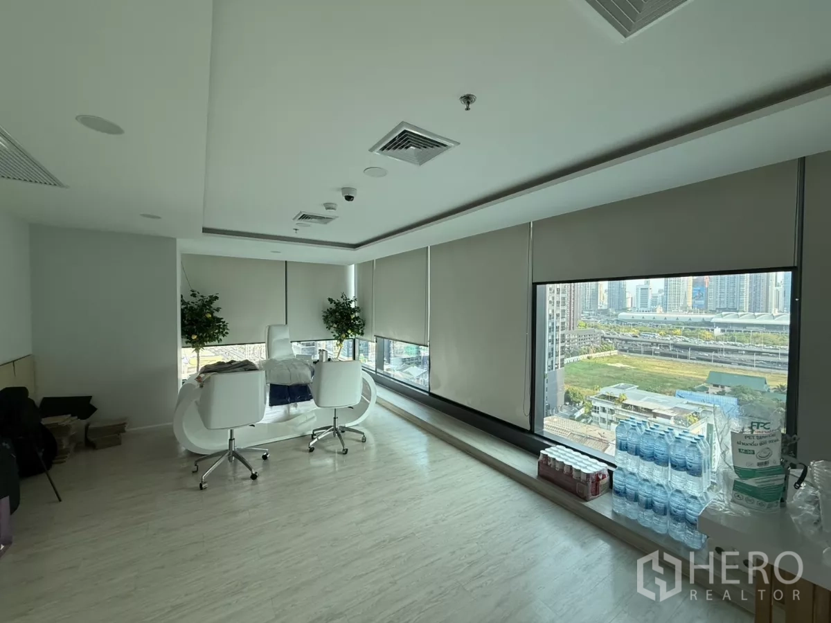 办公空间 出租在Din Daeng, Bangkok - 转角行政办公室，弧形白色办公桌，落地窗享拉玛九片区城市景观。