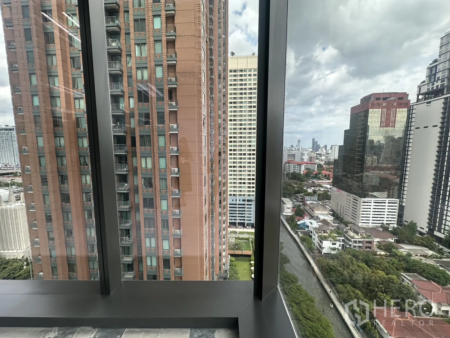 Office Space for rent in Ratchathewi, Bangkok - City view from a glass corner showing nearby high-rise buildings and a canal below.