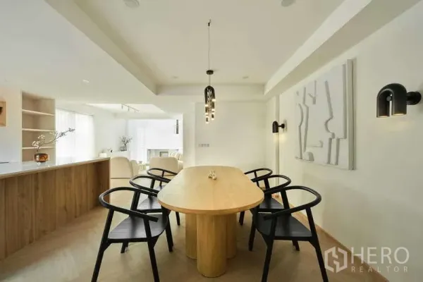 Home Office for sale in Chatuchak, Bangkok - Open‑plan dining and pantry with oval wooden table, black chairs and pendant lighting.