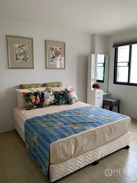 Townhouse for rent in Watthana, Bangkok - Bright guest bedroom with bed, vanity and large window.