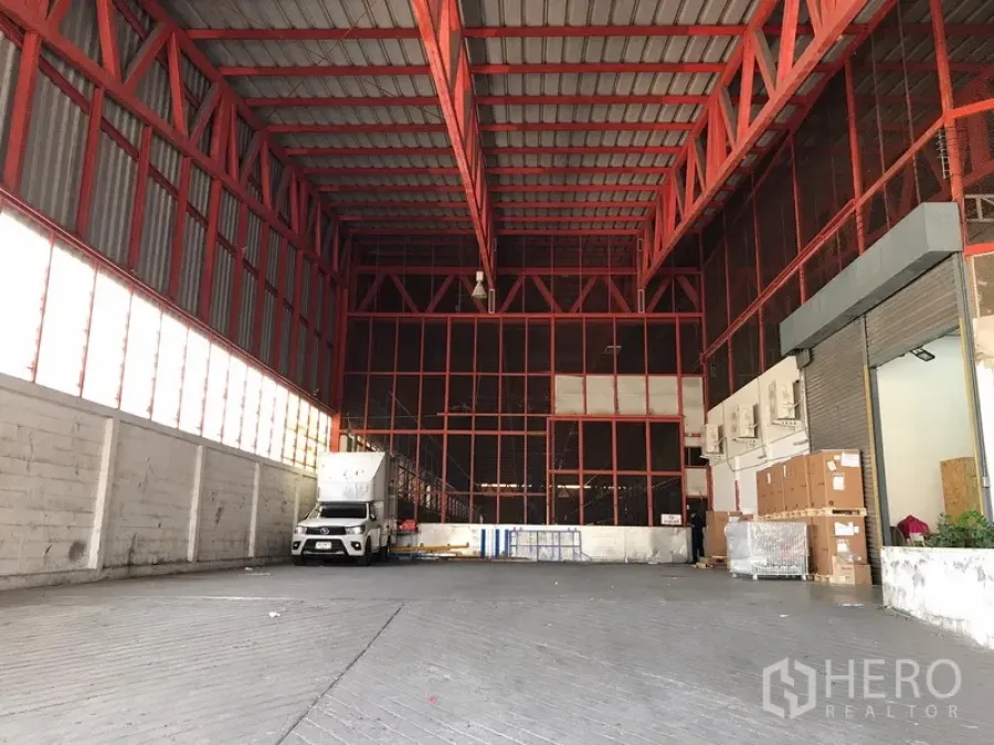 คลังสินค้า ให้เช่าในBang Na, Bangkok - พื้นที่ลานโหลดสินค้าในโกดัง เพดานสูงโครงเหล็กสีแดง รถบรรทุกเข้าออก พร้อมประตูม้วน