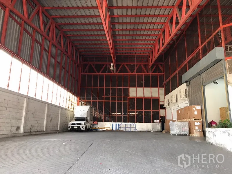 คลังสินค้า ให้เช่าในBang Na, Bangkok - พื้นที่ลานโหลดสินค้าในโกดัง เพดานสูงโครงเหล็กสีแดง รถบรรทุกเข้าออก พร้อมประตูม้วน