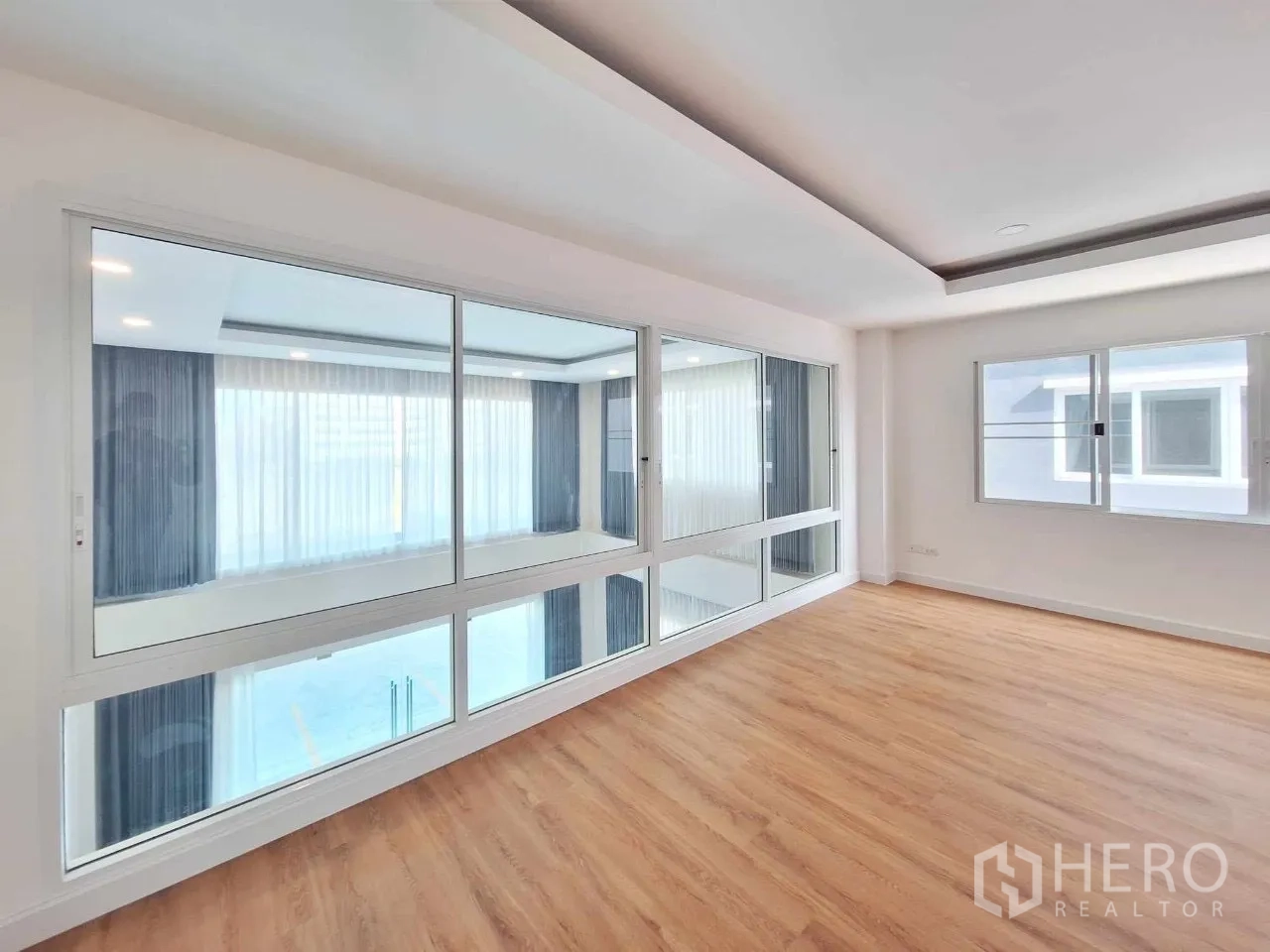 Home Office for sale in Bueng Kum, Bangkok - Glass-partitioned meeting room overlooking the double-height lobby, wood flooring.