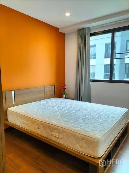 คอนโด ให้เช่าในWatthana, Bangkok - ห้องนอนสว่าง ผนังเน้นสีส้ม หน้าต่างบานใหญ่ และเตียงควีน