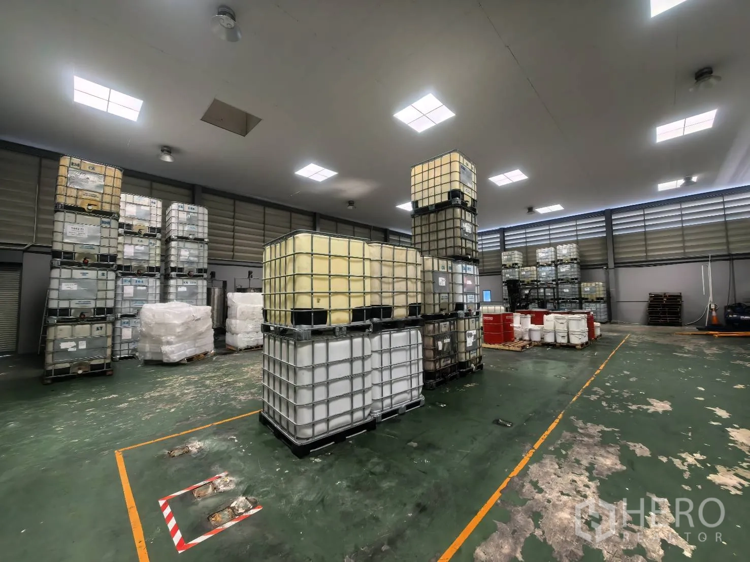 Warehouse for rent in Bang Sao Thong, Samut Prakan - Interior storage hall with marked floor lanes and stacked containers.