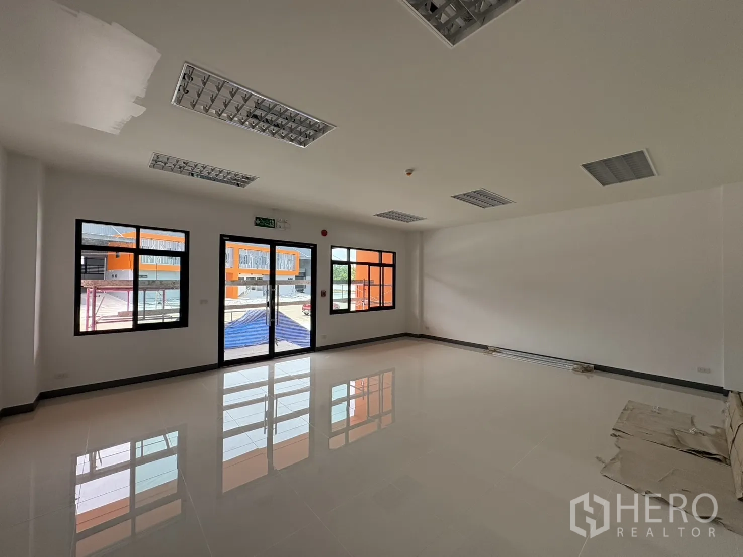 Factory for rent in Bang Pakong, Chachoengsao - Ground-floor office room with glossy tile flooring and large windows.