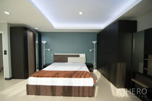 คอนโด ให้เช่าหรือขายในKhlong Toei, Bangkok - ห้องนอนหลักพร้อมฝ้าเพดานซ่อนไฟ ผนังสีเขียวน้ำทะเล เตียงคิงส์ไซส์ และตู้เสื้อผ้าขนาดใหญ่