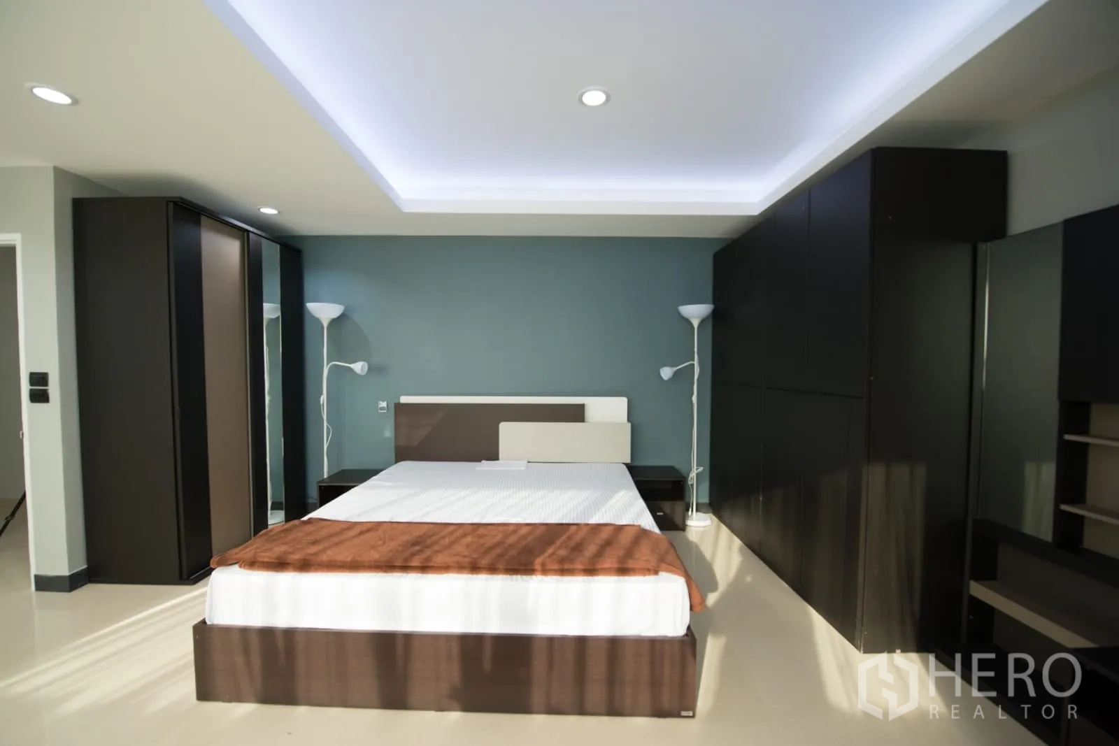 คอนโด ให้เช่าหรือขายในKhlong Toei, Bangkok - ห้องนอนหลักพร้อมฝ้าเพดานซ่อนไฟ ผนังสีเขียวน้ำทะเล เตียงคิงส์ไซส์ และตู้เสื้อผ้าขนาดใหญ่