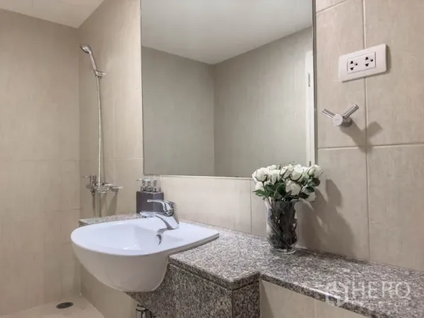 Condominium for sale in Watthana, Bangkok - Close-up of granite vanity with white basin, large mirror, and shower.