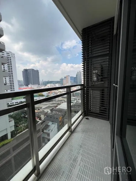 公寓 出租在Khlong Toei, Bangkok - 阳台侧向视角，可见曼谷天际线与云层。