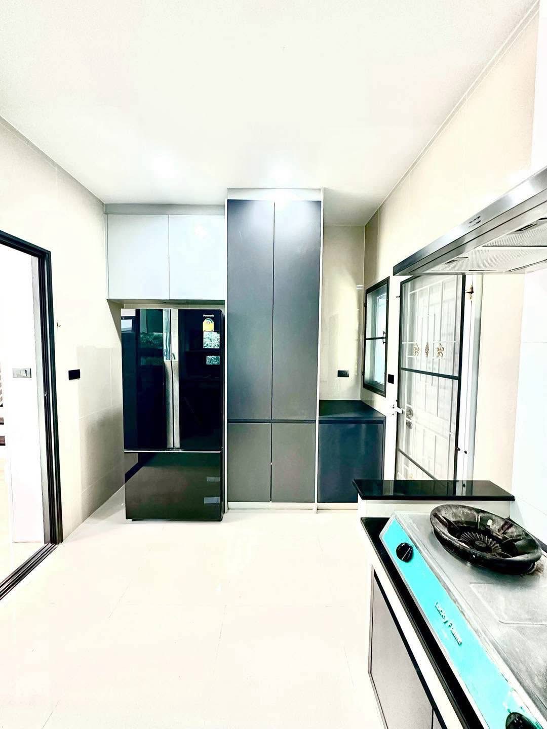 独立式住宅 出租在Bang Kapi, Bangkok - 明亮厨房，高光橱柜与双开门冰箱。