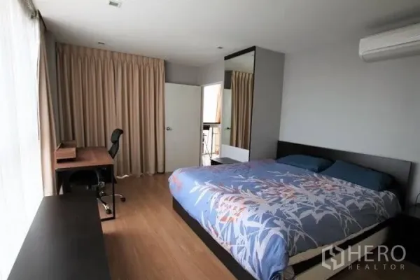 Condominium for rent in Watthana, Bangkok - Spacious master bedroom with king bed, work desk, full-length curtains and balcony access.