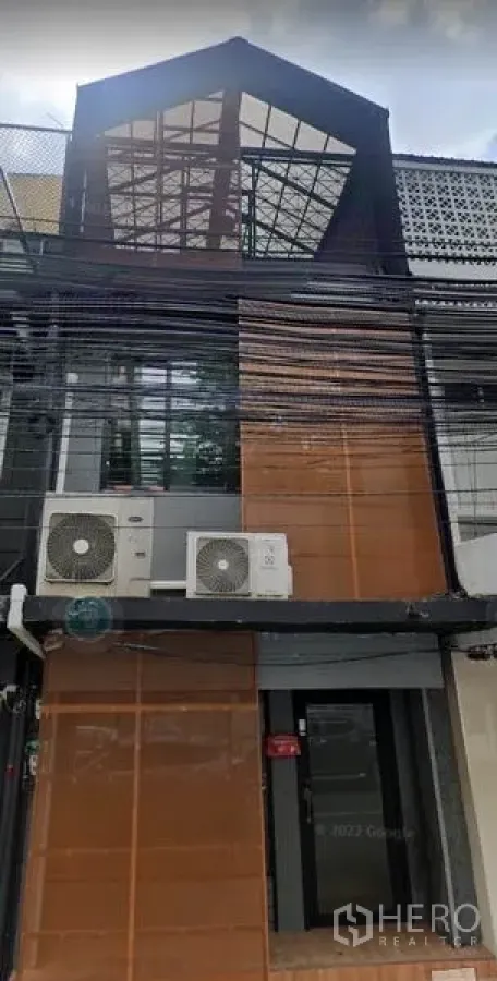 สำนักงานที่บ้าน ขายในBang Rak, Bangkok - ด้านหน้าโฮมออฟฟิศสไตล์ทาวน์เฮาส์ หลังคากระจกทรงจั่ว พร้อมคอมเพรสเซอร์แอร์นอกอาคาร