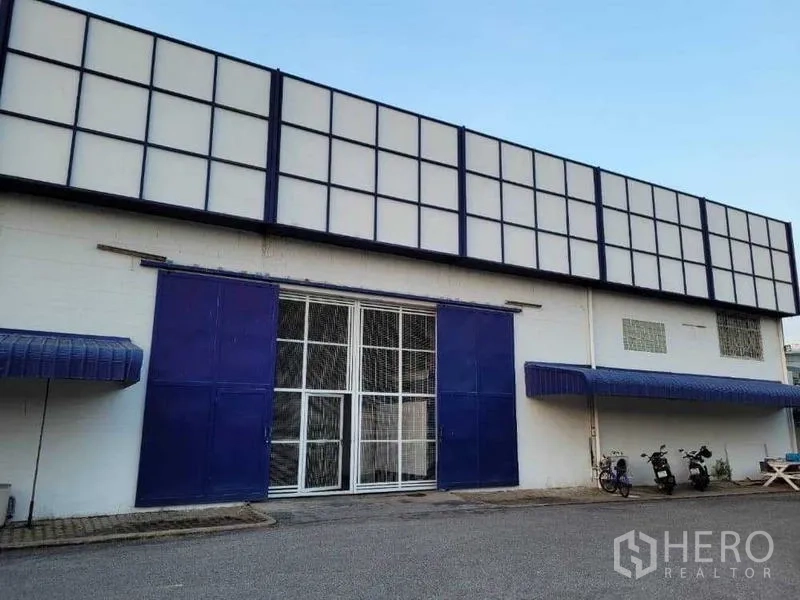 Warehouse for rent in Phra Khanong, Bangkok - Front facade featuring double sliding steel doors and awnings