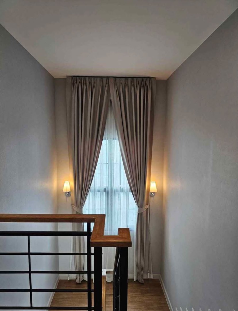 Detached House for rent in Bang Phli, Samut Prakan - Stairwell with wooden handrail, metal balusters, tall window and wall sconces with curtains.