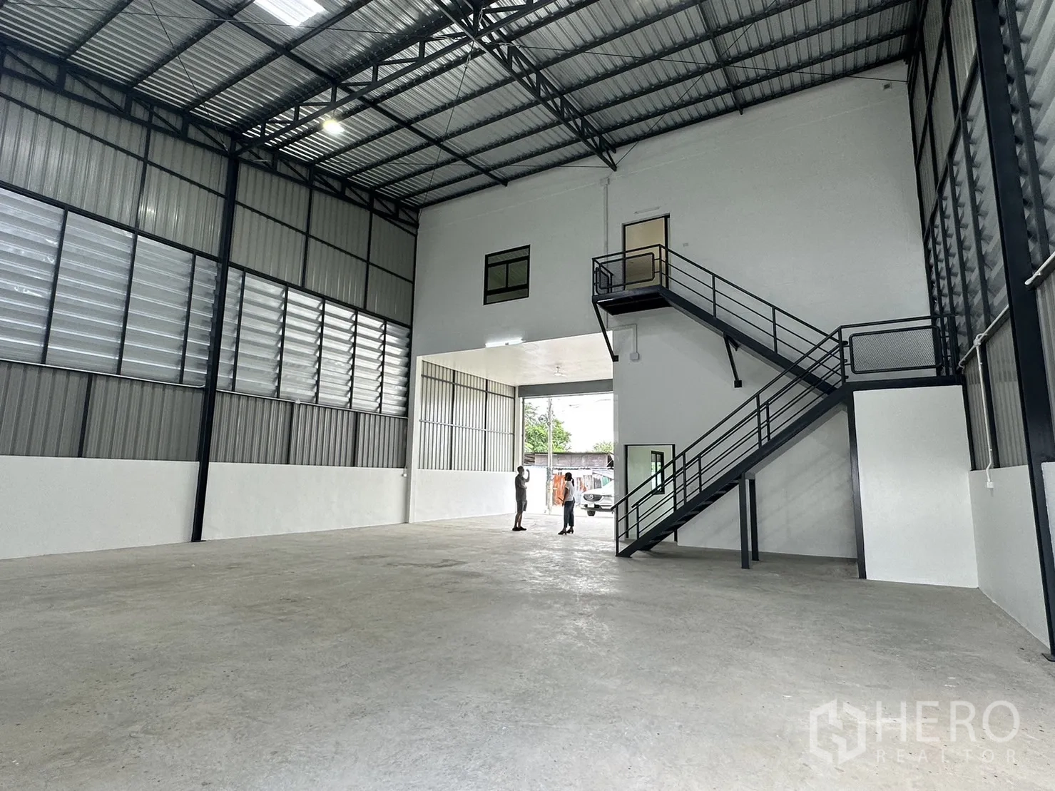 Warehouse for rent or sale - Open warehouse floor with steel stairs and space ready for a mezzanine.