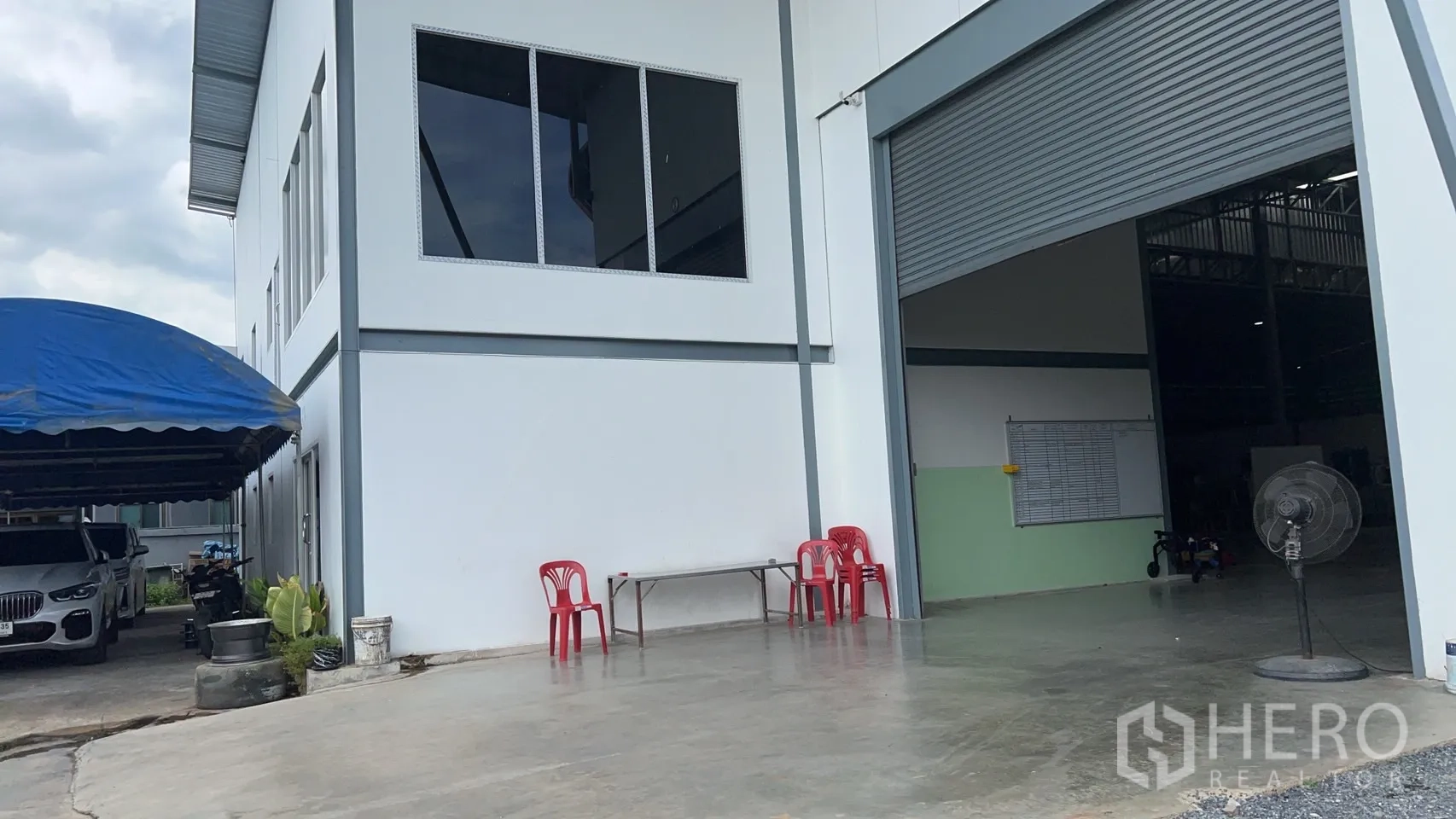 货栈 出售在Lam Luk Ka, Pathum Thani - 装卸区混凝土硬地，白色立面与超大卷帘门。