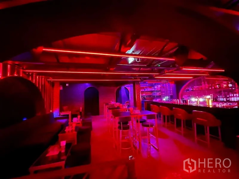 零售空间 出租在Bangkok - 宽敞吧厅，高脚桌、拱形后吧与红色顶灯