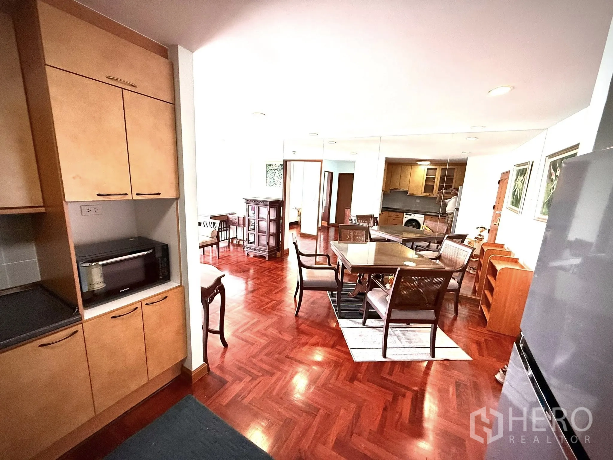 Condominium for rent in Sathon, Bangkok - Dining space facing a mirrored wall leading to the open kitchen and lounge.