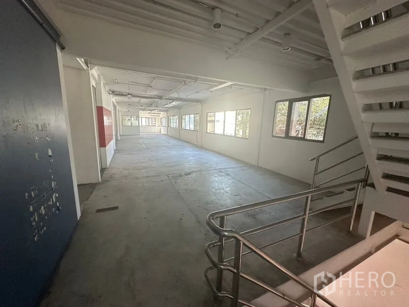 Warehouse for rent in Saphan Sung, Bangkok - Wide internal corridor with windows and metal handrail in Bangkok warehouse office.