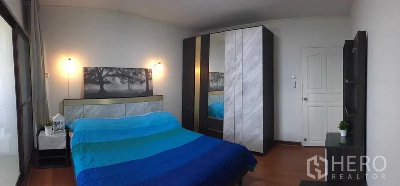 คอนโด ให้เช่าหรือขายในDin Daeng, Bangkok - ห้องนอนที่สองมีผ้าห่มสีน้ำเงิน ตู้เสื้อผ้าทันสมัย และโต๊ะข้างเตียง.