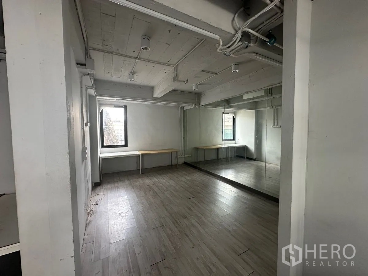 带办公室的家 出租在Chatuchak, Bangkok - 工作室风格房间，木纹地板，整面镜墙与外露管线。