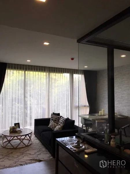 คอนโด ให้เช่าในWatthana, Bangkok - พื้นที่นั่งเล่นแบบเปิดโล่ง มีโซฟา โต๊ะทานอาหาร และม่านโปร่งต่อเชื่อมสู่ระเบียง
