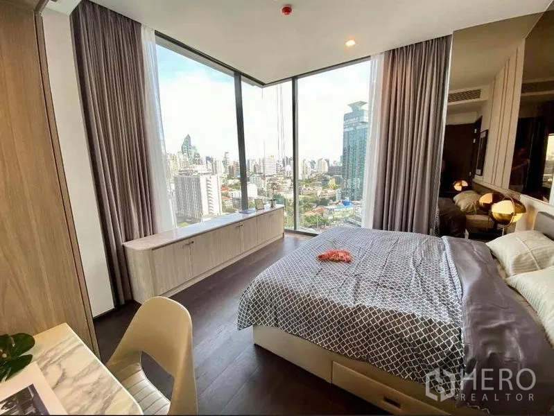Condominium for rent in Watthana, Bangkok - Corner bedroom featuring panoramic glass walls, storage cabinet and skyline outlook.