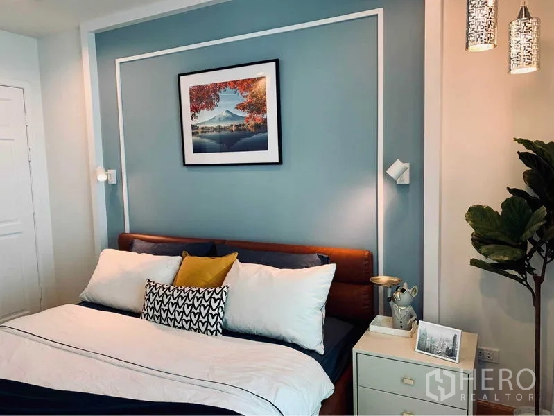 คอนโด ให้เช่าในWatthana, Bangkok - ห้องนอนใหญ่ผนังหัวเตียงสีฟ้าอ่อน โคมแขวน และภาพวิว