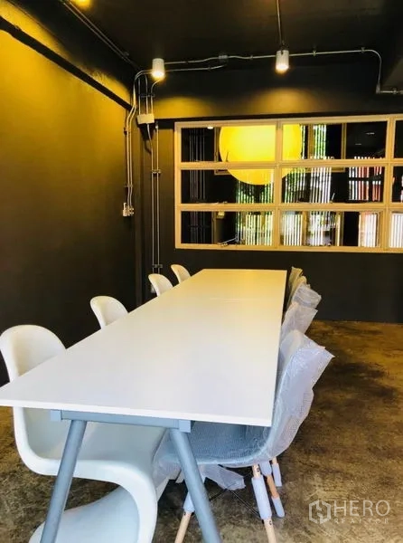 สำนักงานที่บ้าน ให้เช่าในHuai Khwang, Bangkok - ห้องประชุมโต๊ะยาวสีขาว เก้าอี้สีขาว และไฟมินิมอล.