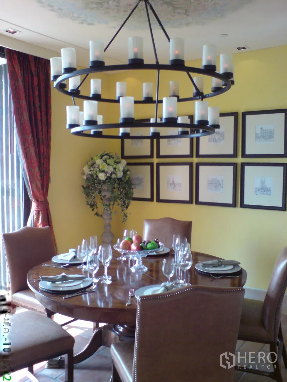Condominium for rent in Khlong Toei, Bangkok - Formal dining room with round wooden table, leather chairs and candle-style chandelier.