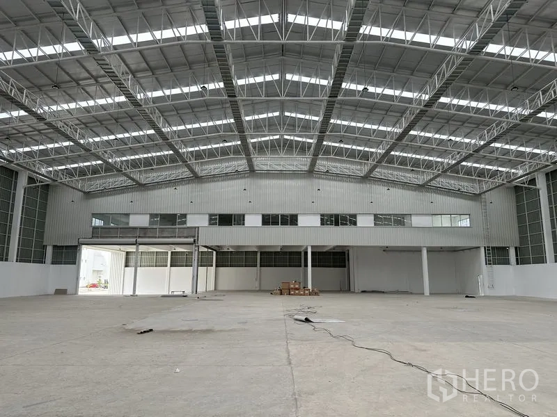 Factory for rent in Pathum Thani - Wide, high-ceiling manufacturing space with clerestory windows and mezzanine.