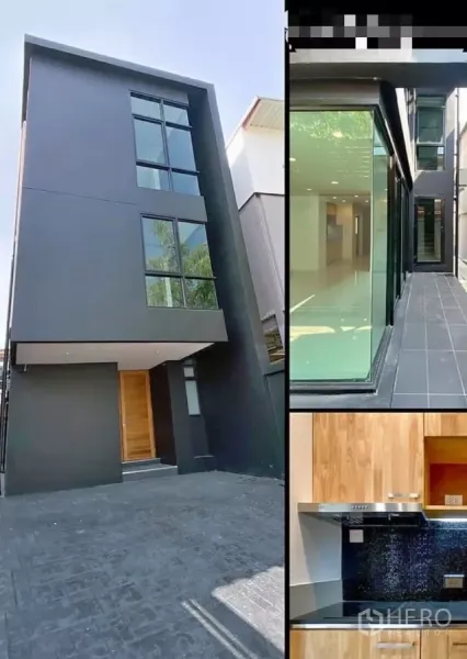 Detached House for rent in Huai Khwang, Bangkok - Contemporary black exterior with tall windows, side glass walkway, and built‑in wood kitchen.