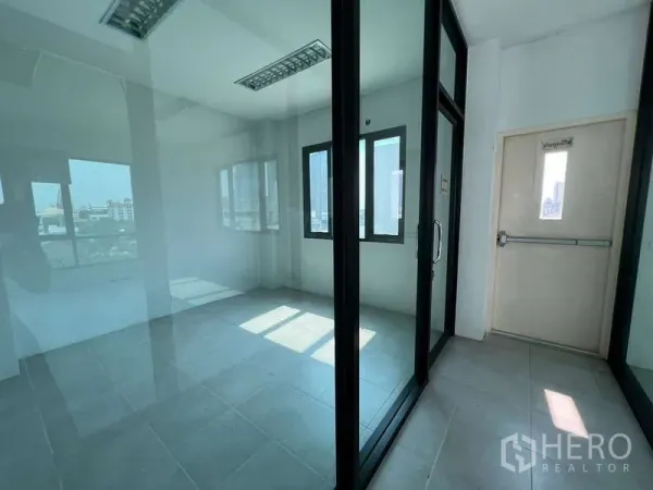 Office Space for sale in Bang Na, Bangkok - Small glass-partitioned office room with windows and city views.