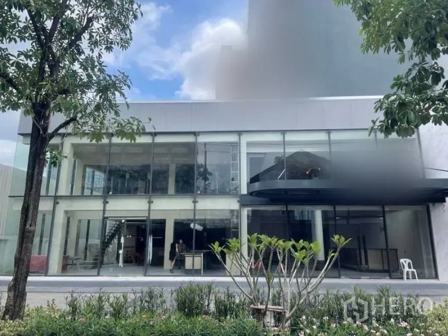 零售空间 出租在Phra Khanong, Bangkok - 现代两层玻璃立面的商业建筑，前方园景，位于曼谷帕卡农。