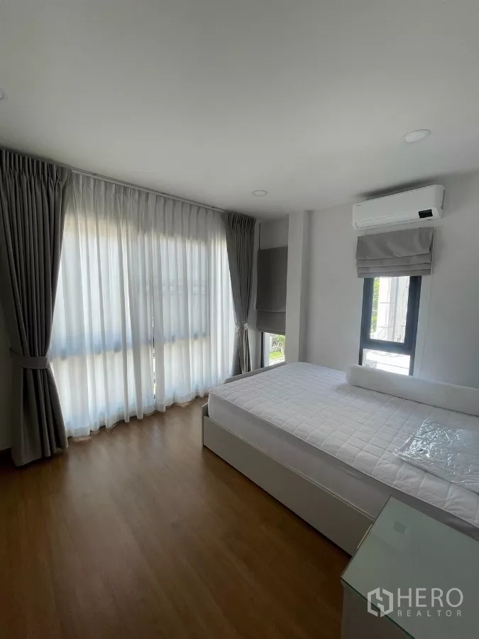 独立式住宅 出租在Bang Phli, Samut Prakan - 转角卧室配大窗与纱帘，设大床。