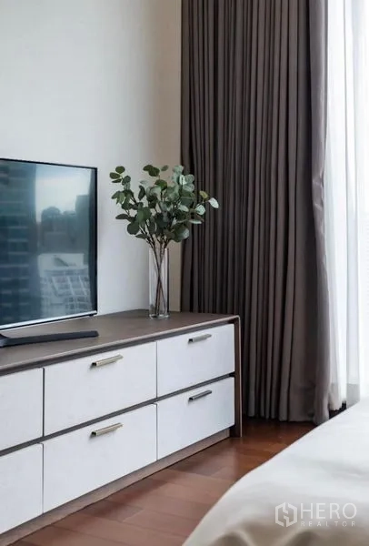 คอนโด ให้เช่า - ตู้ลิ้นชักวางทีวีพร้อมแจกันต้นไม้ ข้างผ้าม่านแบบเต็มความสูง