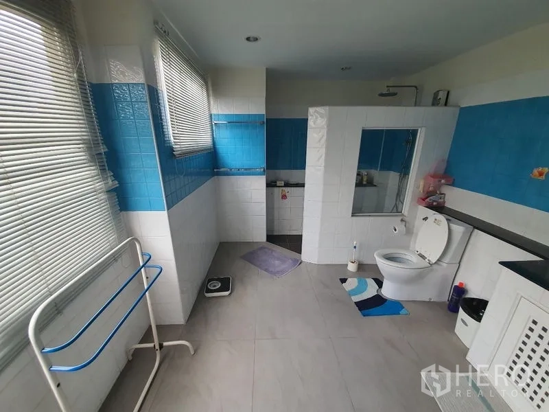 Townhouse for rent in Phaya Thai, Bangkok - Bathroom angle showing rain shower, windows with blinds and long countertop.