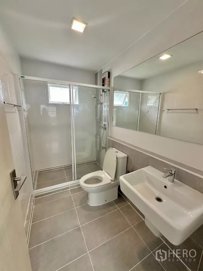 Detached House for rent in Bang Phli, Samut Prakan - Side garden with artificial turf, metal bench and white perimeter fence.