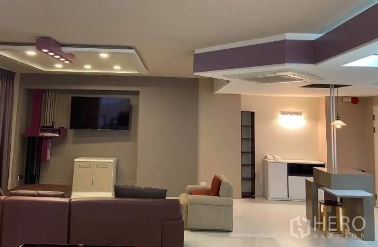 คอนโด ให้เช่าในWatthana, Bangkok - โซนนั่งเล่นพร้อมผนังทีวี ไฟตกแต่ง และที่นั่งหลายมุมโทนอบอุ่น